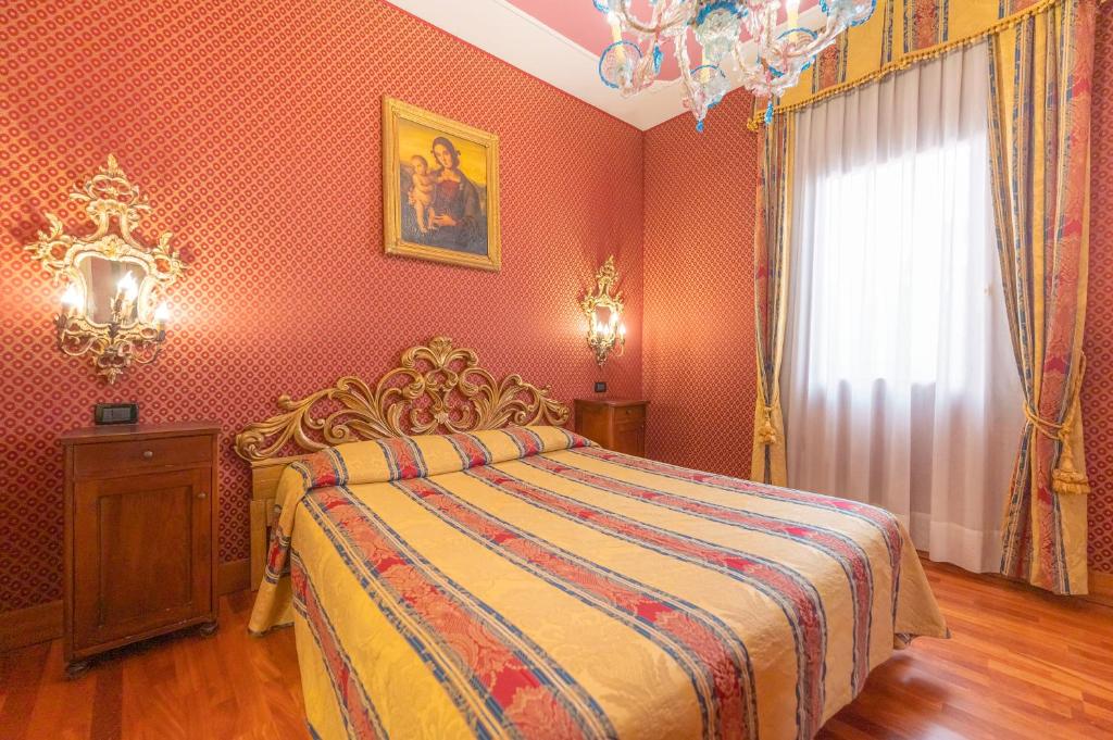 a bedroom with a bed in a room with red walls at Cà Valeri in Venice