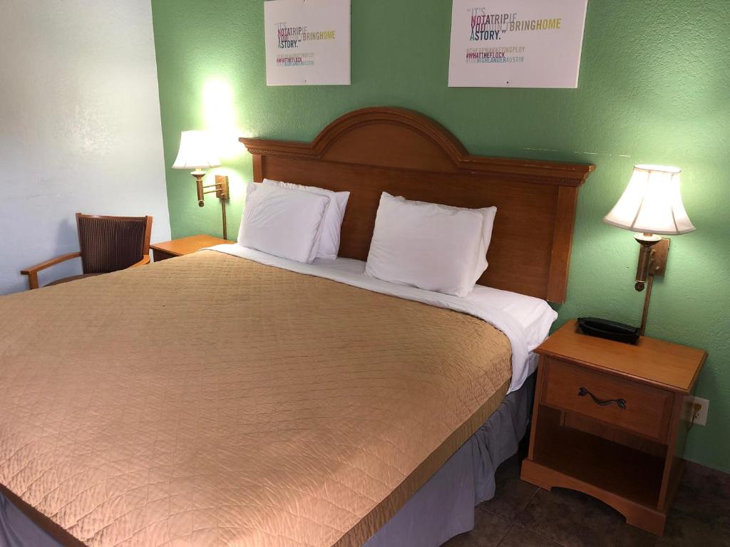 um quarto com uma cama grande e paredes verdes em Hwy 59 Motel Laredo Medical Center em Laredo