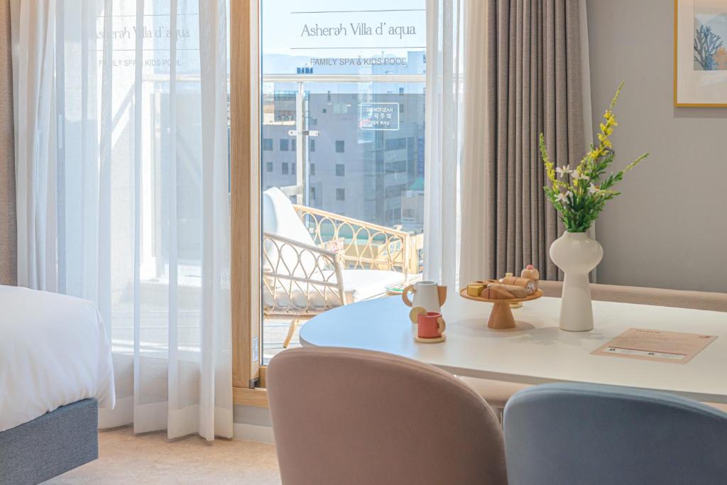 Gimhae的住宿－Asherah Villa d' aqua Hotel，客房设有桌椅和阳台。
