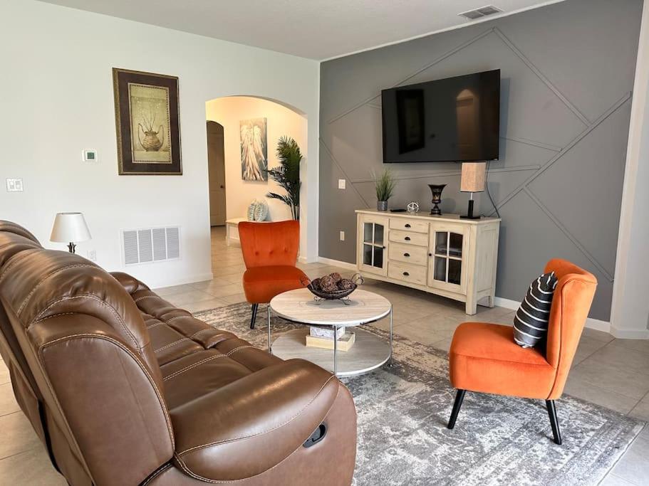 uma sala de estar com um sofá de couro castanho e cadeiras em * Brand New Vacation Home * em Haines City