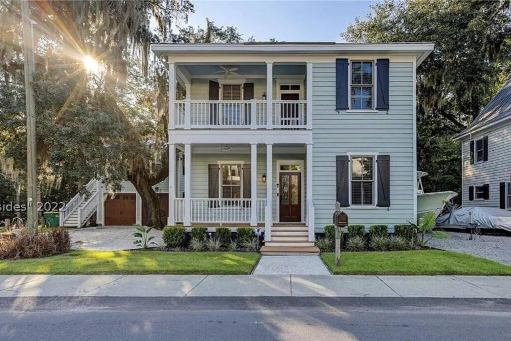 a white house with a white porch and a balcony at The Bluffton Village Home - 5 BR in Old Town w Carriage Home in Bluffton