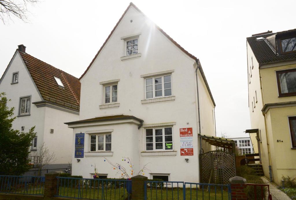 uma casa branca com um telhado preto em Airportgästehaus Bremen em Bremen