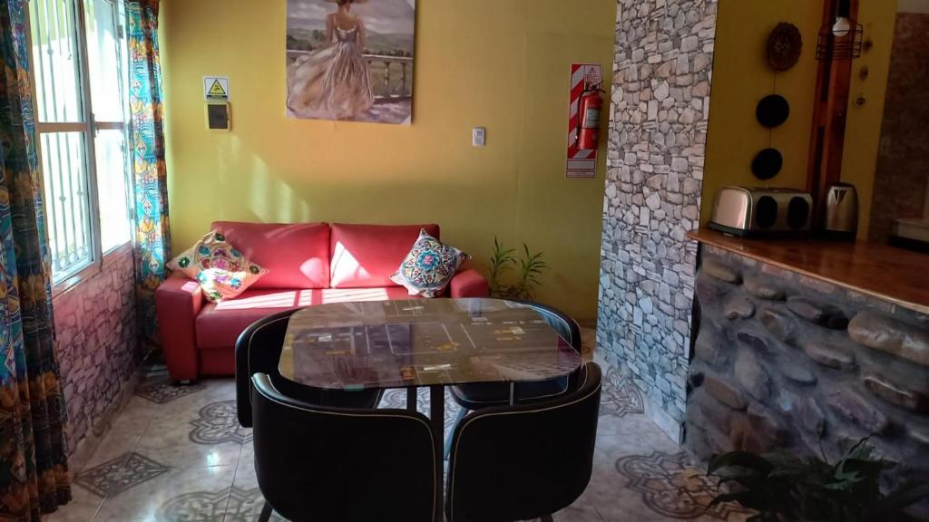 a living room with a red couch and a glass table at Brisa del Cielo in Salta