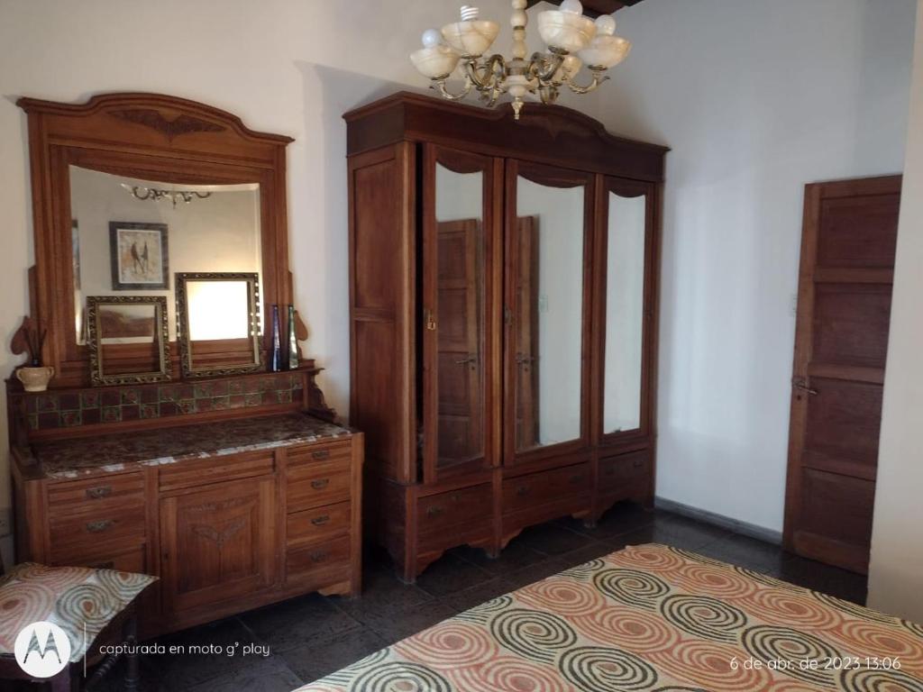 een slaapkamer met een grote houten dressoir en een spiegel bij Casona Veroka in San Pedro