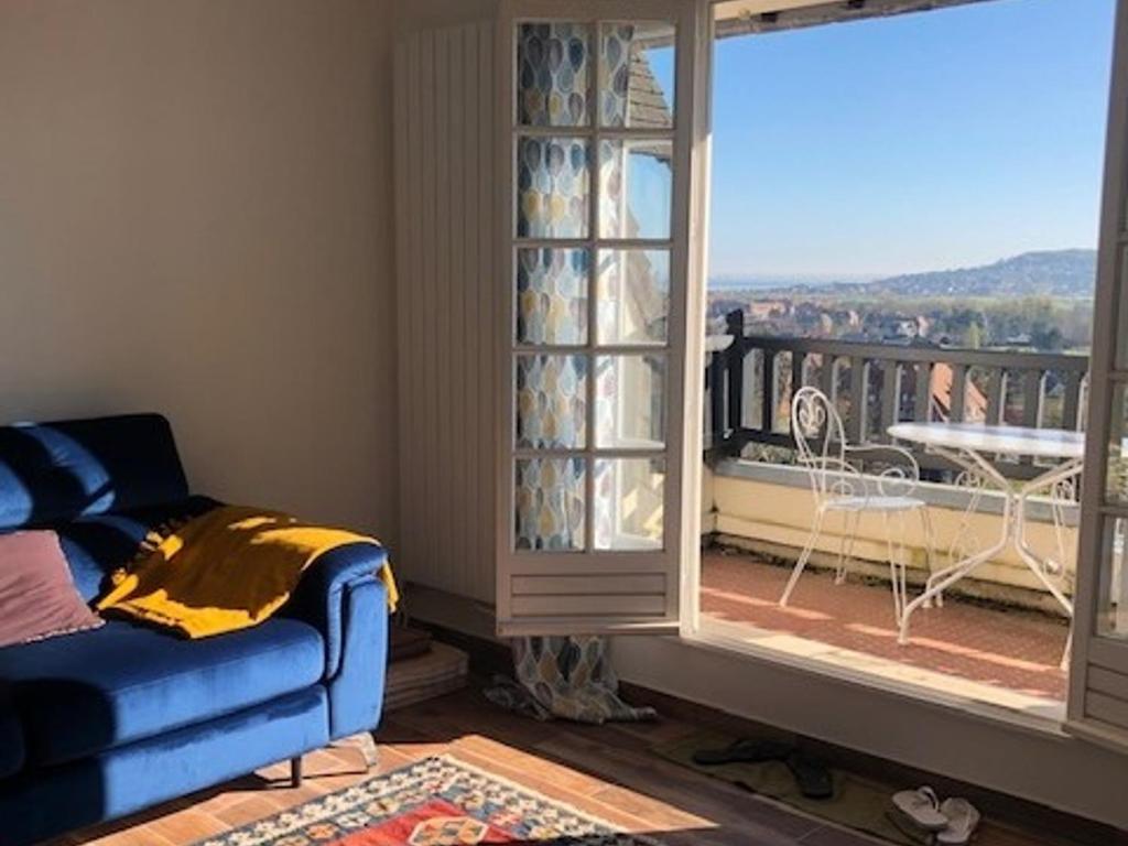sala de estar con sofá y balcón en Appartement Villers-sur-Mer, 1 pièce, 2 personnes - FR-1-712-3, en Villers-sur-Mer