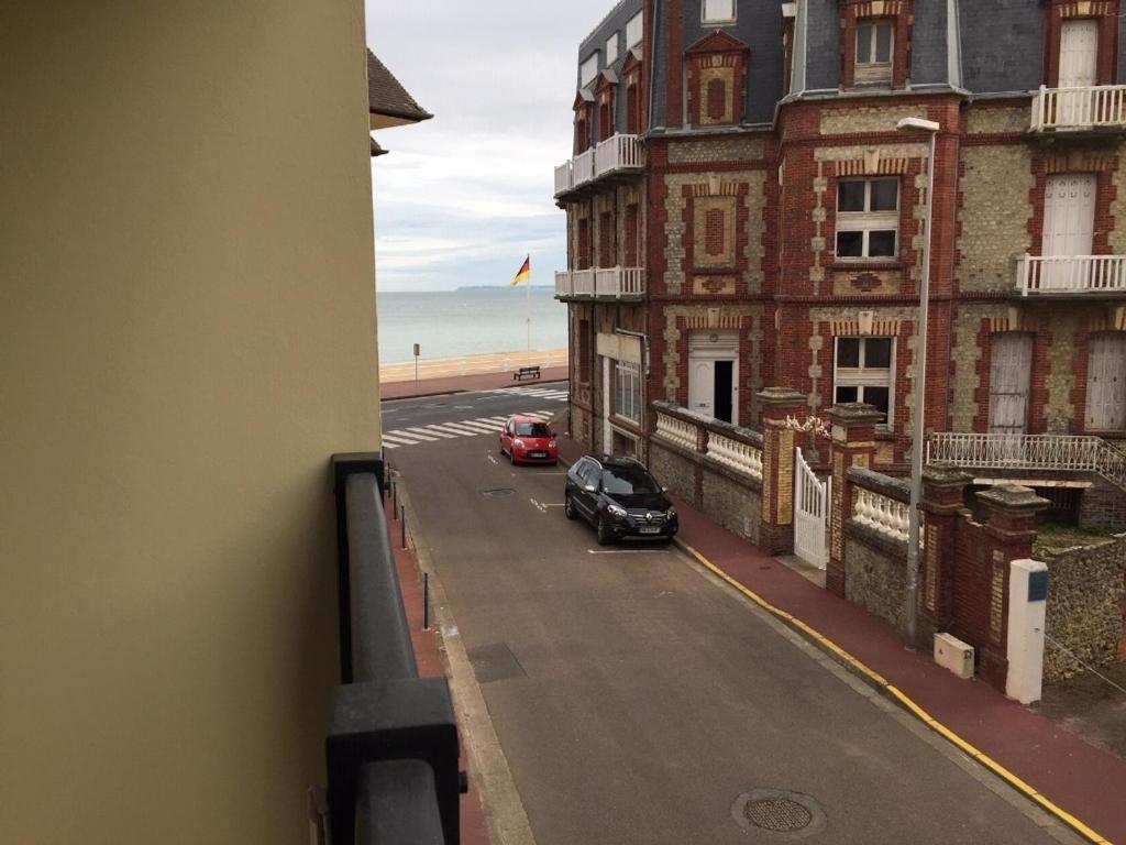 - un balcon offrant une vue sur un bâtiment et une rue dans l'établissement Grand studio familial avec balcon et parking à 2 pas de la plage et du centre de Villers-sur-Mer - FR-1-712-2, à Villers-sur-Mer
