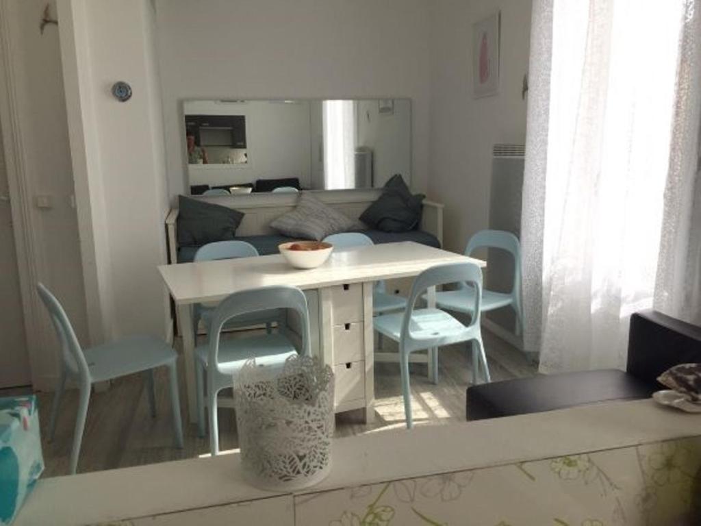 ein Wohnzimmer mit einem weißen Tisch und Stühlen in der Unterkunft Appartement Blonville-sur-Mer, 2 pièces, 4 personnes - FR-1-712-31 in Blonville-sur-Mer