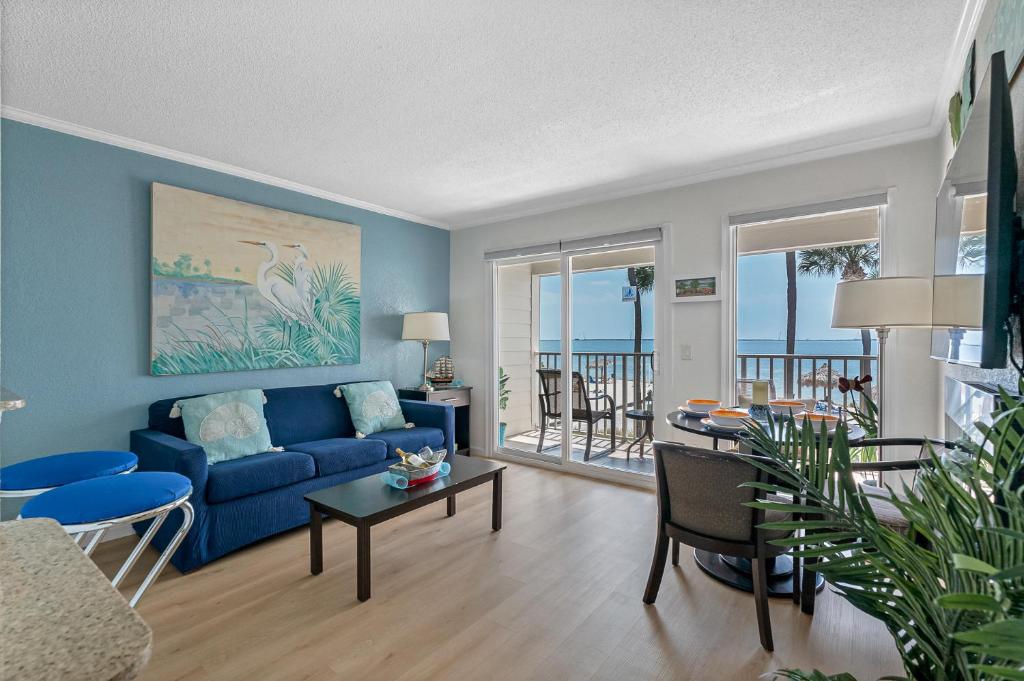 a living room with a blue couch and a table at Paradise Beach Sailport Resort Condo in Tampa