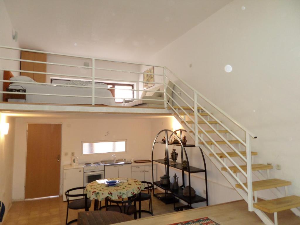 a room with a staircase and a table and a kitchen at Green River Apartment in Mostar
