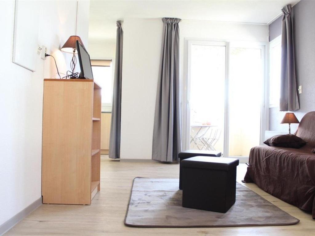 a living room with a bed and a dresser and a chair at Appartement La Rochelle, 2 pièces, 4 personnes - FR-1-246-648 in La Rochelle