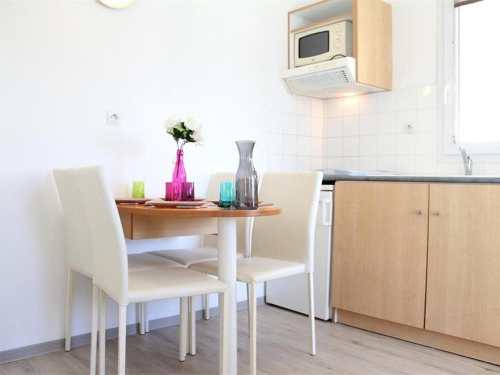 a kitchen with a table and chairs in a kitchen at Appartement La Rochelle, 2 pièces, 4 personnes - FR-1-246-648 in La Rochelle