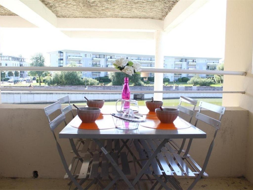 a table with bowls and a vase on a balcony at Appartement La Rochelle, 2 pièces, 4 personnes - FR-1-246-648 in La Rochelle