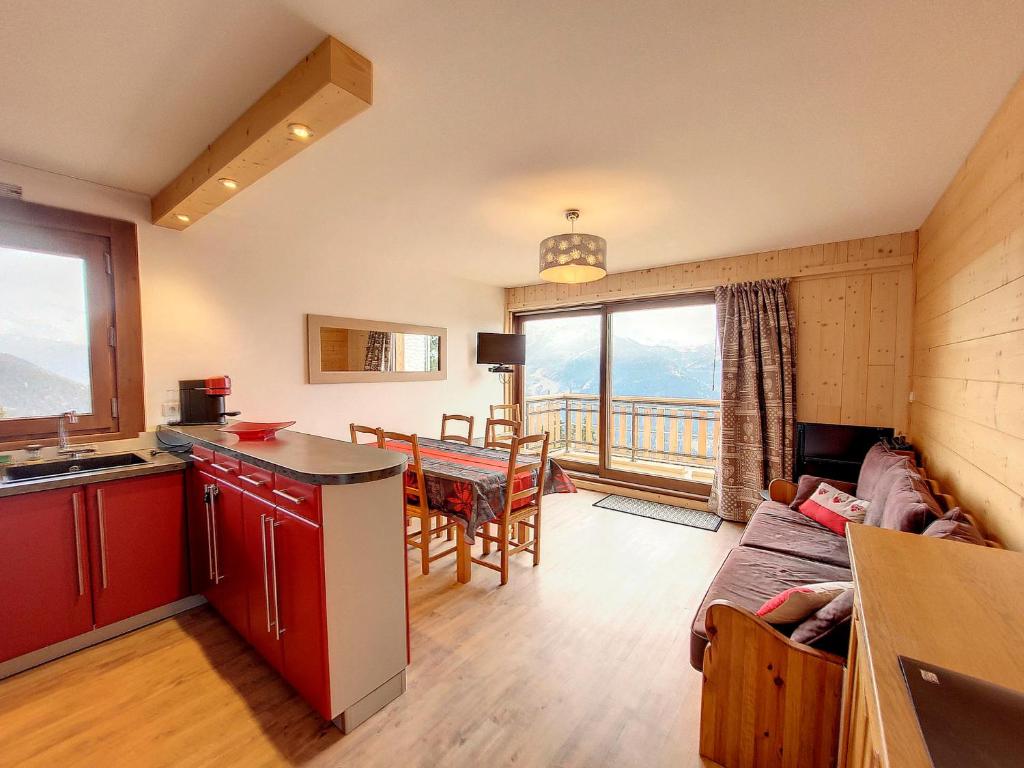une cuisine et un salon avec un canapé et une table dans l'établissement Appartement lumineux avec balcon - 2 chambres - 5 personnes - Centre station - FR-1-275-198, à La Rosière