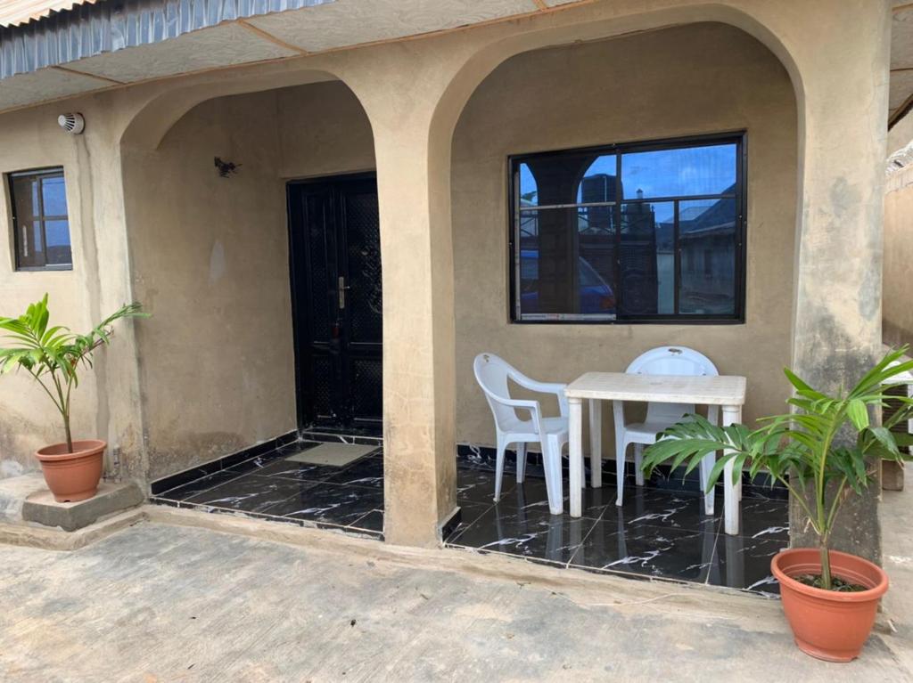 una casa con patio con mesa y sillas en New Bungalow 2 Bed House in Adewumi, Off Olodo rd Ibadan, en Ibadán