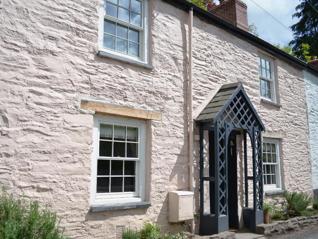 a white building with a black door and windows at Norfolk House in Dulverton