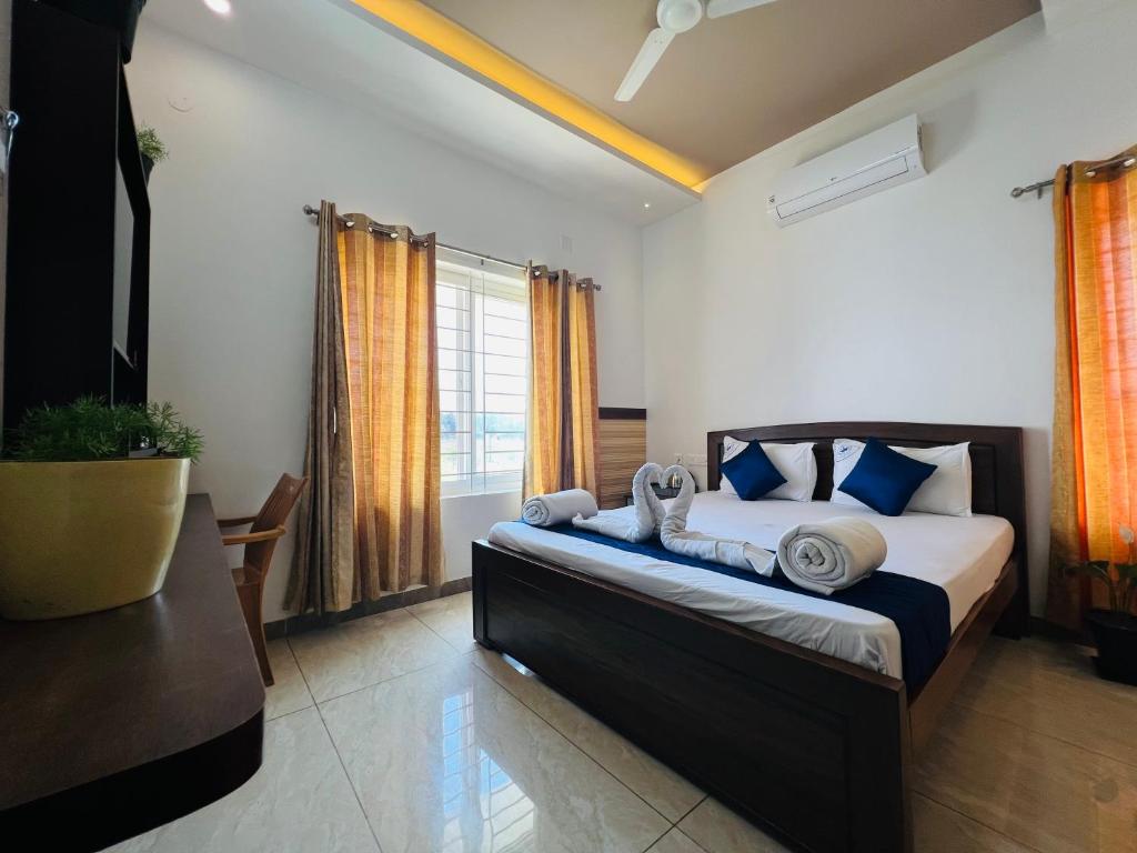 a bedroom with a bed with blue and white pillows at Raja Residency in Alāndurai