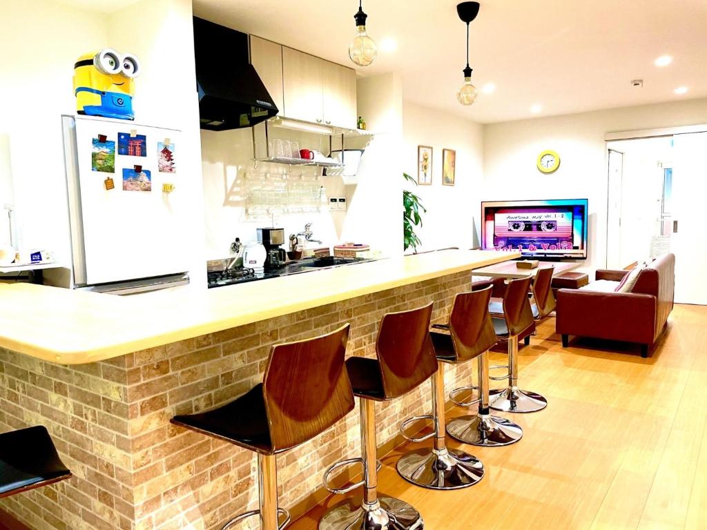 cocina con barra con sillas y TV en Guest House Kirara - Vacation STAY 88539 en Osaka