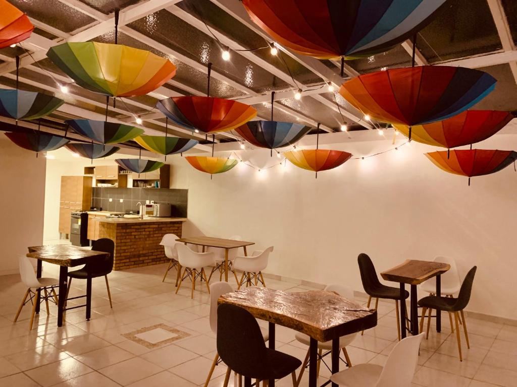 un restaurant avec des tables, des chaises et des parasols suspendus au plafond dans l'établissement CASA CREAZZO 62 - Movistar Arena, à Bogotá