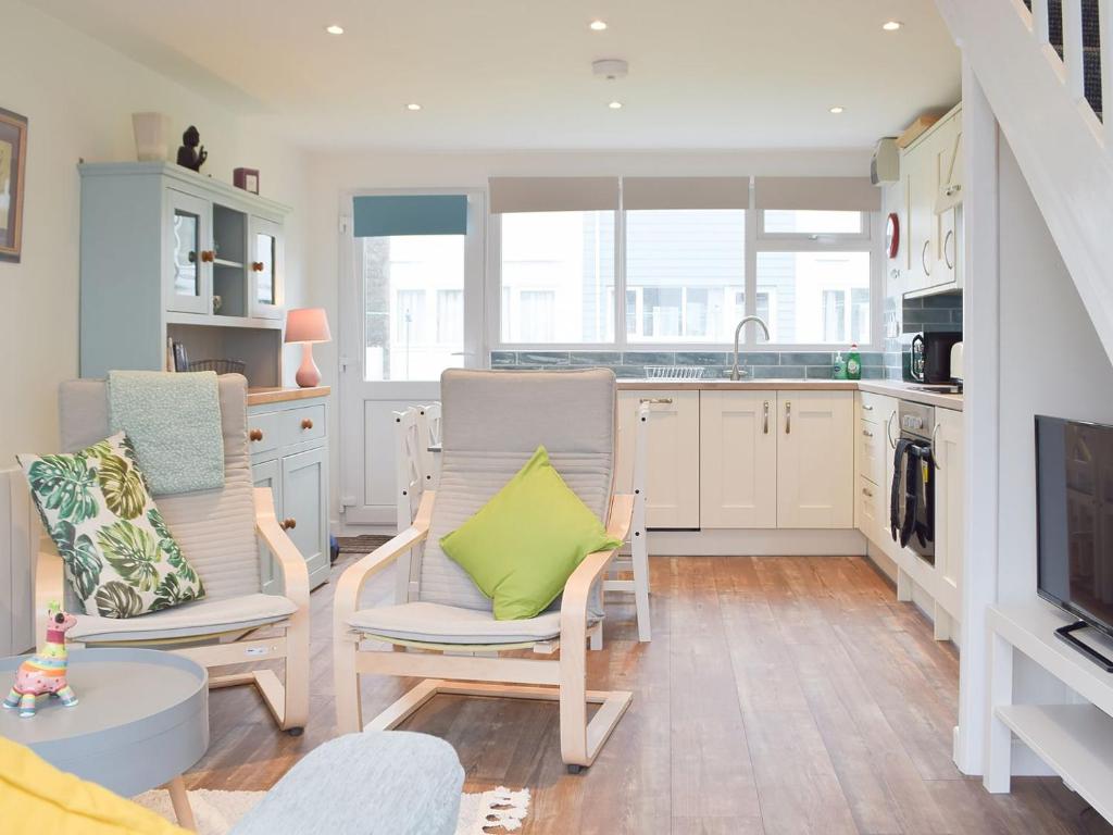 a kitchen with two chairs and a green pillow at Sanderling - Uk32837 in Hodgeston
