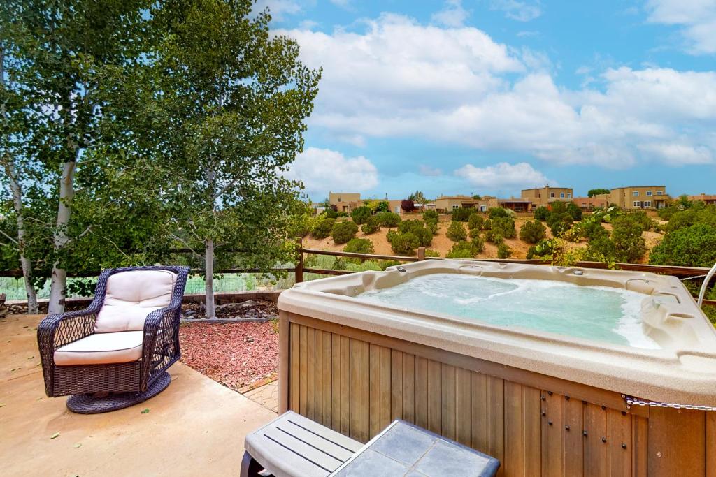 a hot tub sitting on a patio with a chair at Casa Vistoso in Santa Fe