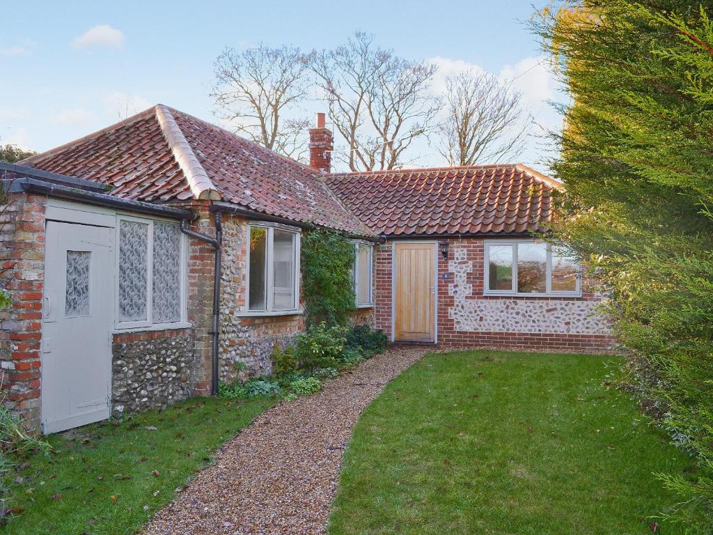 a brick house with a yard in front of it at The Old Stables in Cley next the Sea