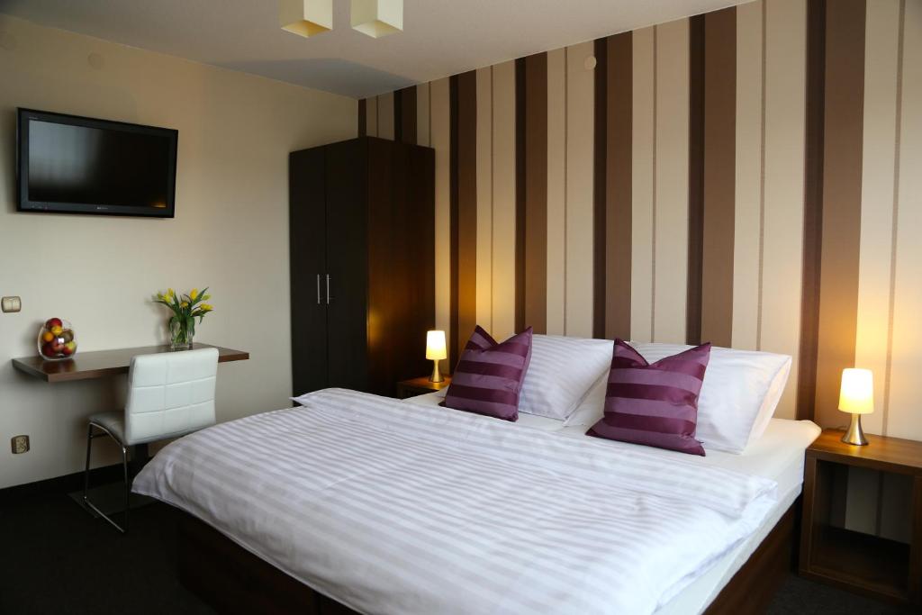 sypialnia z dużym białym łóżkiem z fioletowymi poduszkami w obiekcie 10 Bed And Breakfast w Poznaniu