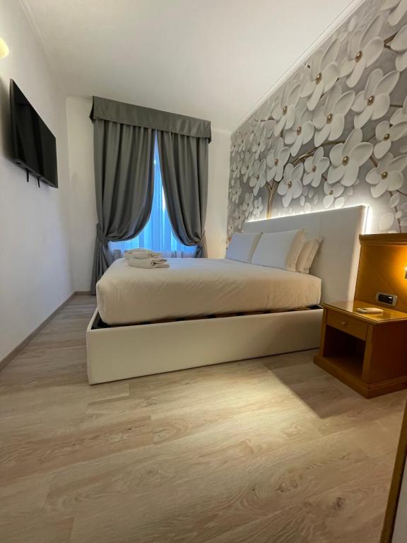 ein Schlafzimmer mit einem großen Bett und einem großen Fenster in der Unterkunft Roma dei Papi Hotel de Charme in Rom