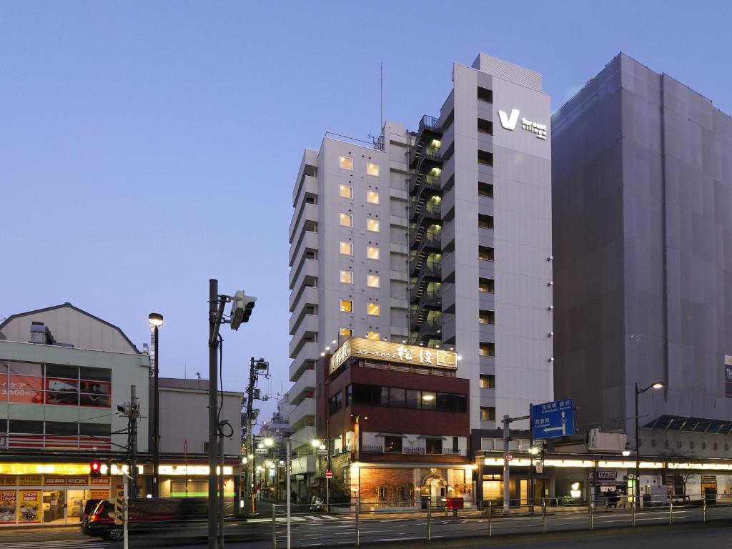 Un palazzo alto con un cartello sul lato. di Far East Village Hotel Tokyo, Asakusa a Tokyo