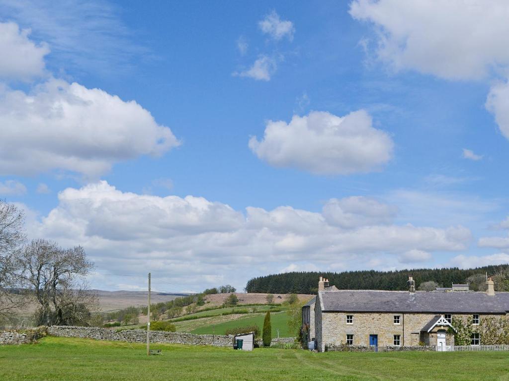 an old house in a field with a stone wall at Rose Cottage in Rochester