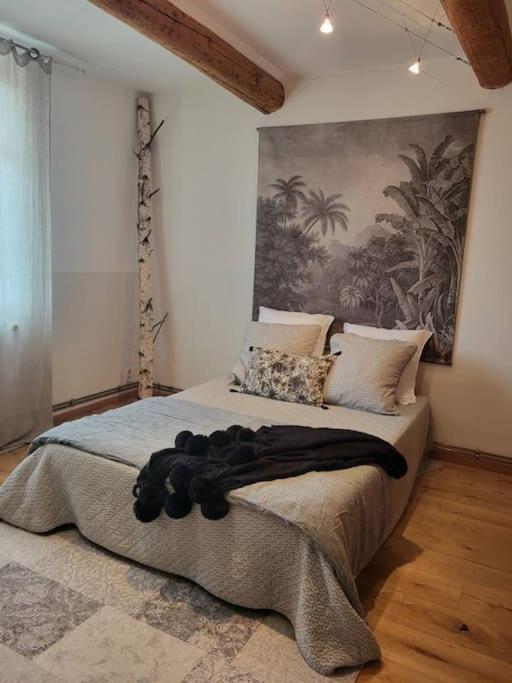 1 dormitorio con 1 cama grande y una pintura en la pared en Mas provençal, en Sarrians