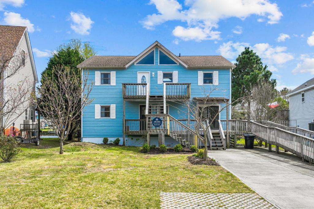 a blue house with a porch and a deck at The Sandy Eagle in Kill Devil Hills