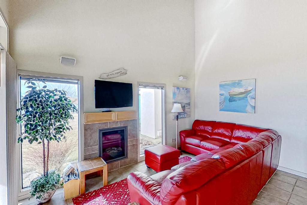 a living room with a red couch and a fireplace at Lake Chelan Shores The Lake Escape 3 1 in Chelan