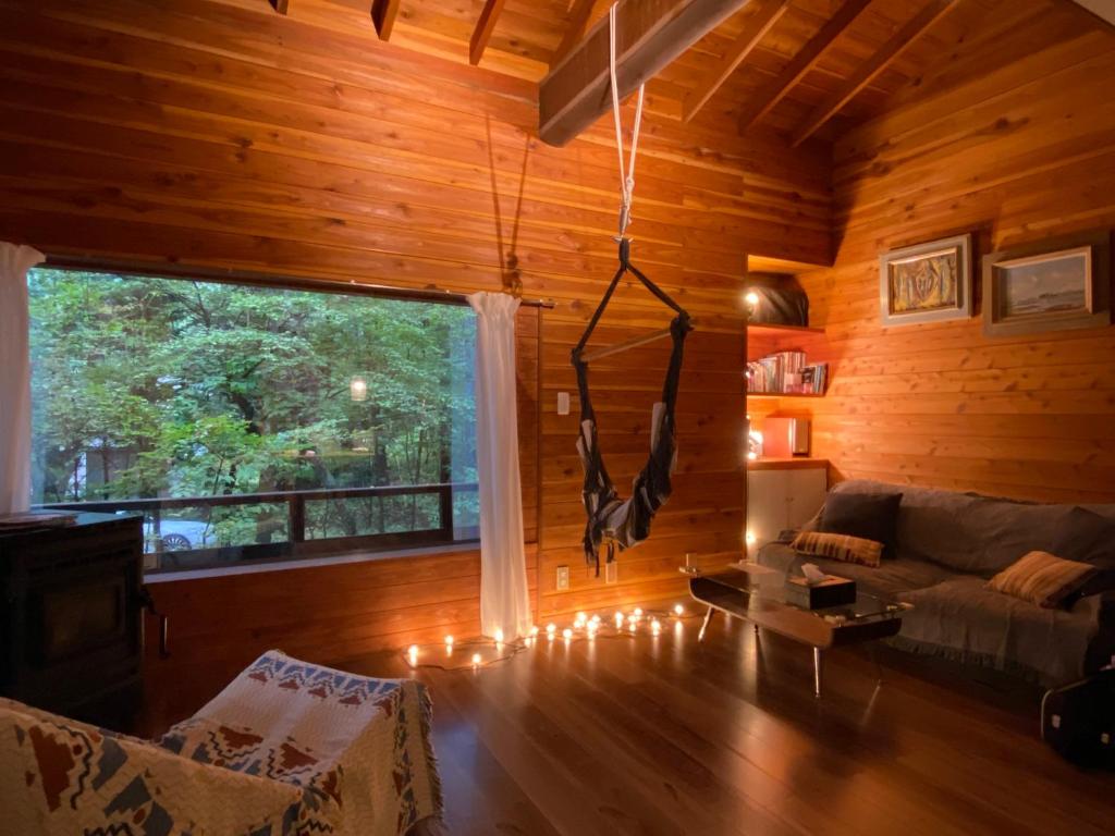 ein Wohnzimmer mit einem Sofa und einem Fenster in der Unterkunft KOMOREBI House -北軽井沢 木漏れ日の家- ペット可 in Kita-karuizawa