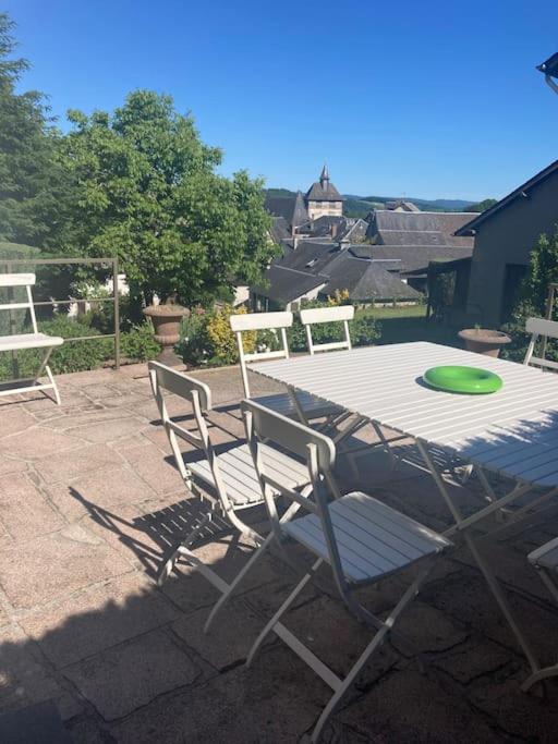 a patio with a table and chairs and a frisbee at Maison place champs de foire 6 pers 4 chambres jardin terrasse in Chamberet