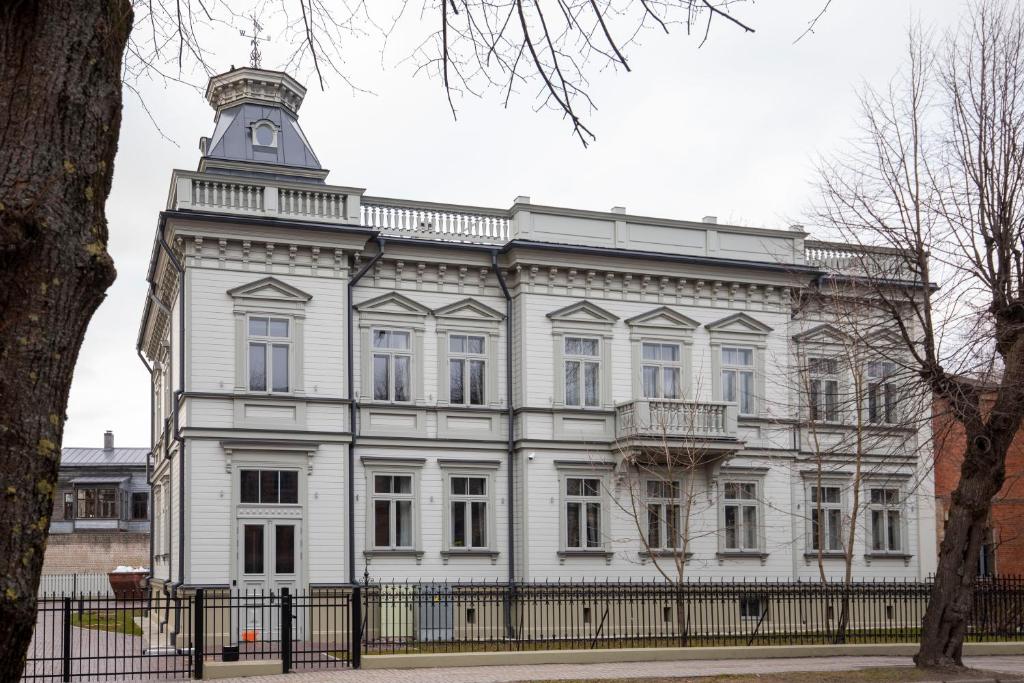 un edificio blanco con una torre encima en Roze Kūrmājas Residence en Liepāja