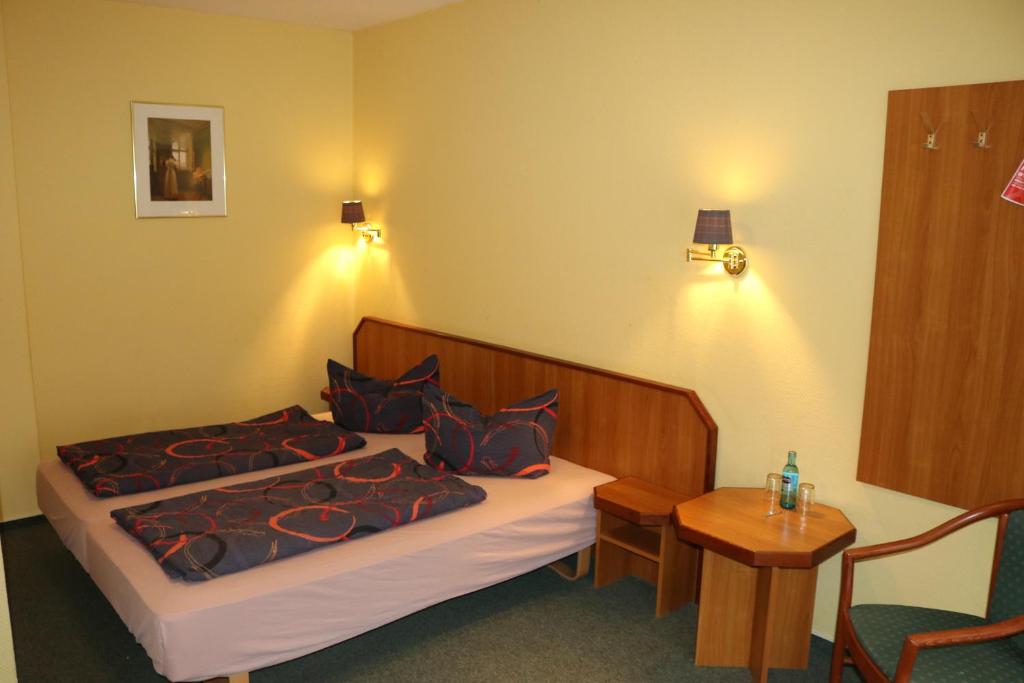 a hotel room with a bed and a table at Stadthotel Brandenburger Hof in Neuruppin