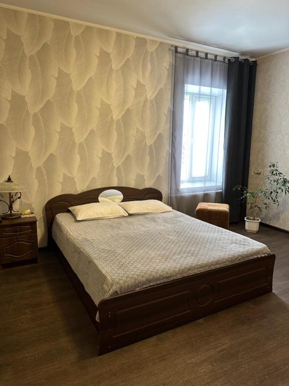 um quarto com uma cama e uma parede com uma janela em Vesela Bdzhilka em Sumy