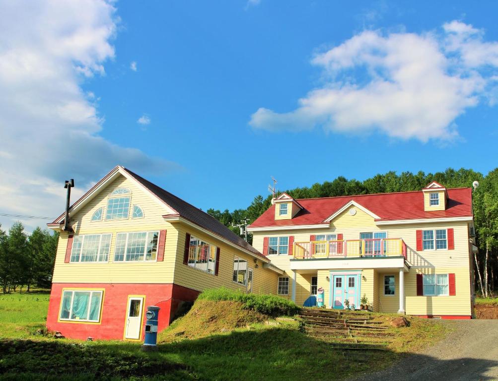 uma casa grande com telhado vermelho em Pension Hoshi Ni Negaiwo em Furano