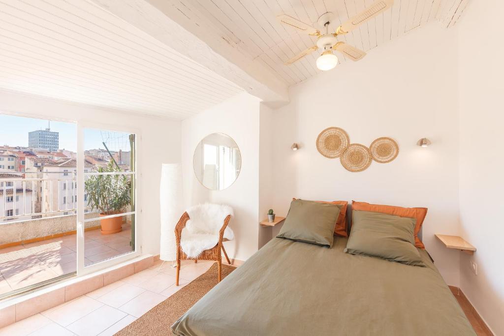 une chambre avec un grand lit et une fenêtre dans l'établissement Charmant Dupleix,toit terrasse, à Toulon