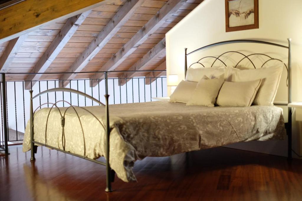 um quarto com uma cama de metal com almofadas brancas em B&B Belvedere em Lurago Marinone