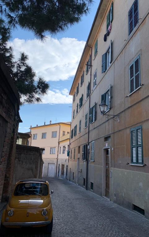 a yellow car parked on a street next to a building at Clara Luna appartamento turistico in Osimo