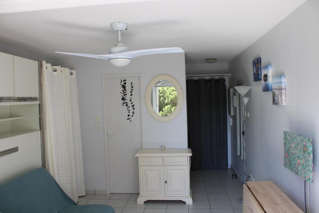a living room with a ceiling fan and a table at Studio l&#39;Echappée mandréenne le calme entre mer et forêt in Saint-Mandrier-sur-Mer