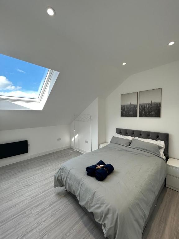 a bedroom with a large bed with a large window at Modern London Apartment in London
