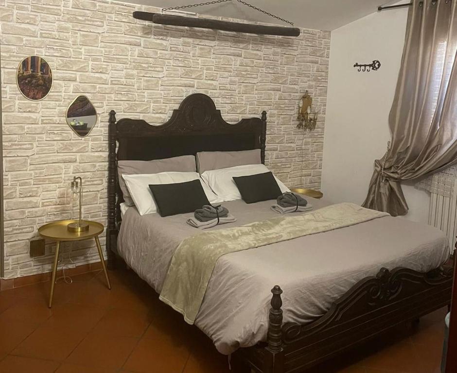 ein Schlafzimmer mit einem Bett und einer Ziegelwand in der Unterkunft Stenghe Stracche in Ascoli Piceno