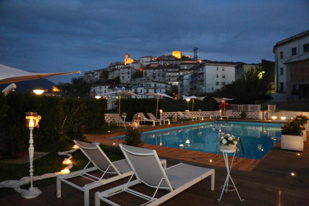 basen z krzesłami i budynkiem w obiekcie Albergo Ristorante Cavaliere w mieście Caselle in Pittari