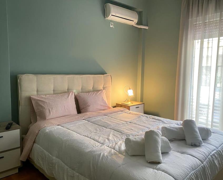Cozy new apartment near the beach في أثينا: غرفة نوم بسرير ابيض مع مخدات ونافذة