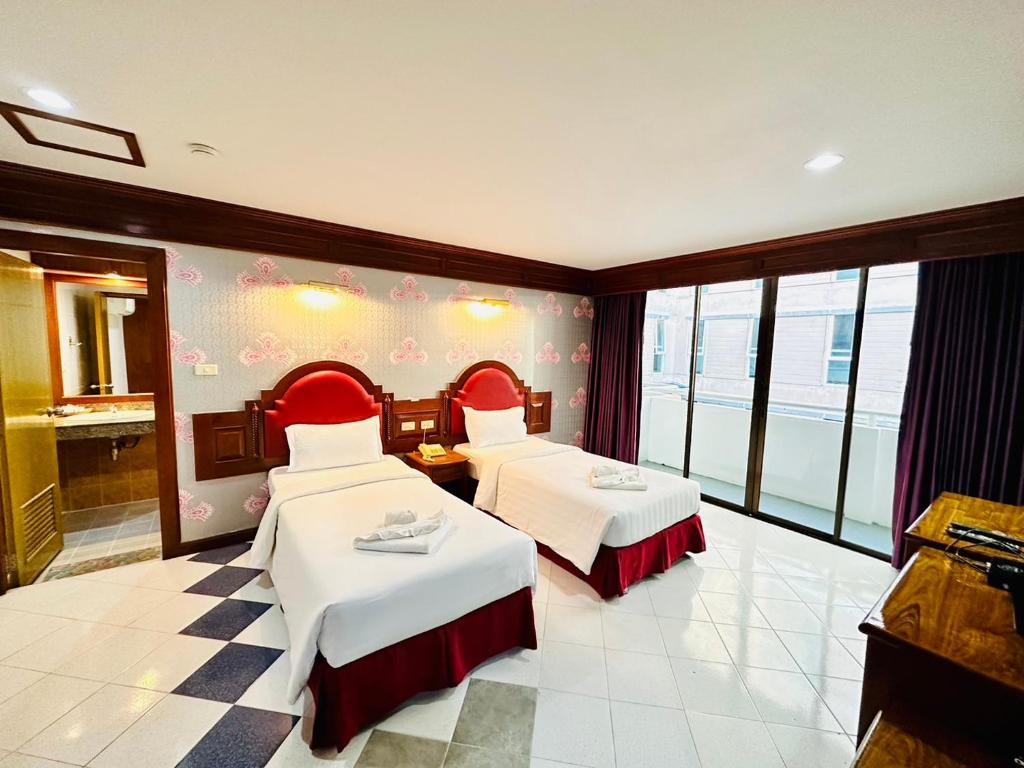 a hotel room with two beds and a bathroom at Lime Hotel in Patong Beach