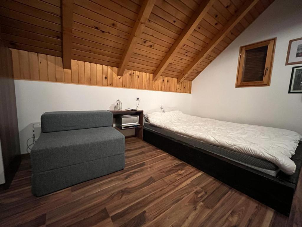 1 dormitorio con 1 cama y 1 silla en Cesargradska klet, en Tuhelj