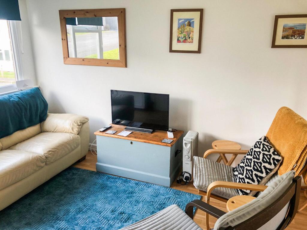 a living room with a couch and a flat screen tv at Sandpiper - Uk36291 in Hodgeston