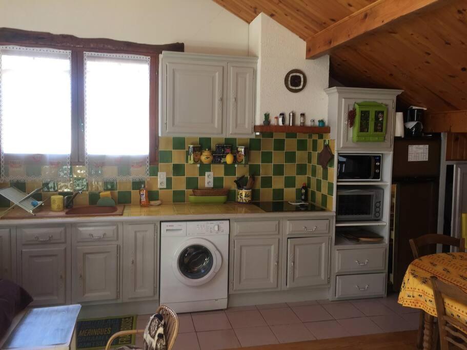 une cuisine avec des armoires blanches et une machine à laver dans l'établissement A corner relaxat° all comfort duplex T4bis COLMARS, à Colmars